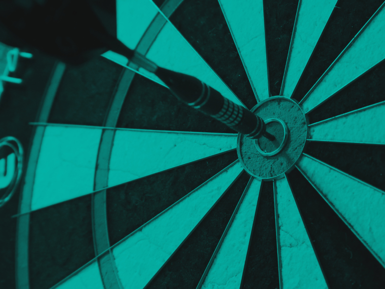 Dart striking the bullseye on a dartboard with a teal colour scheme.